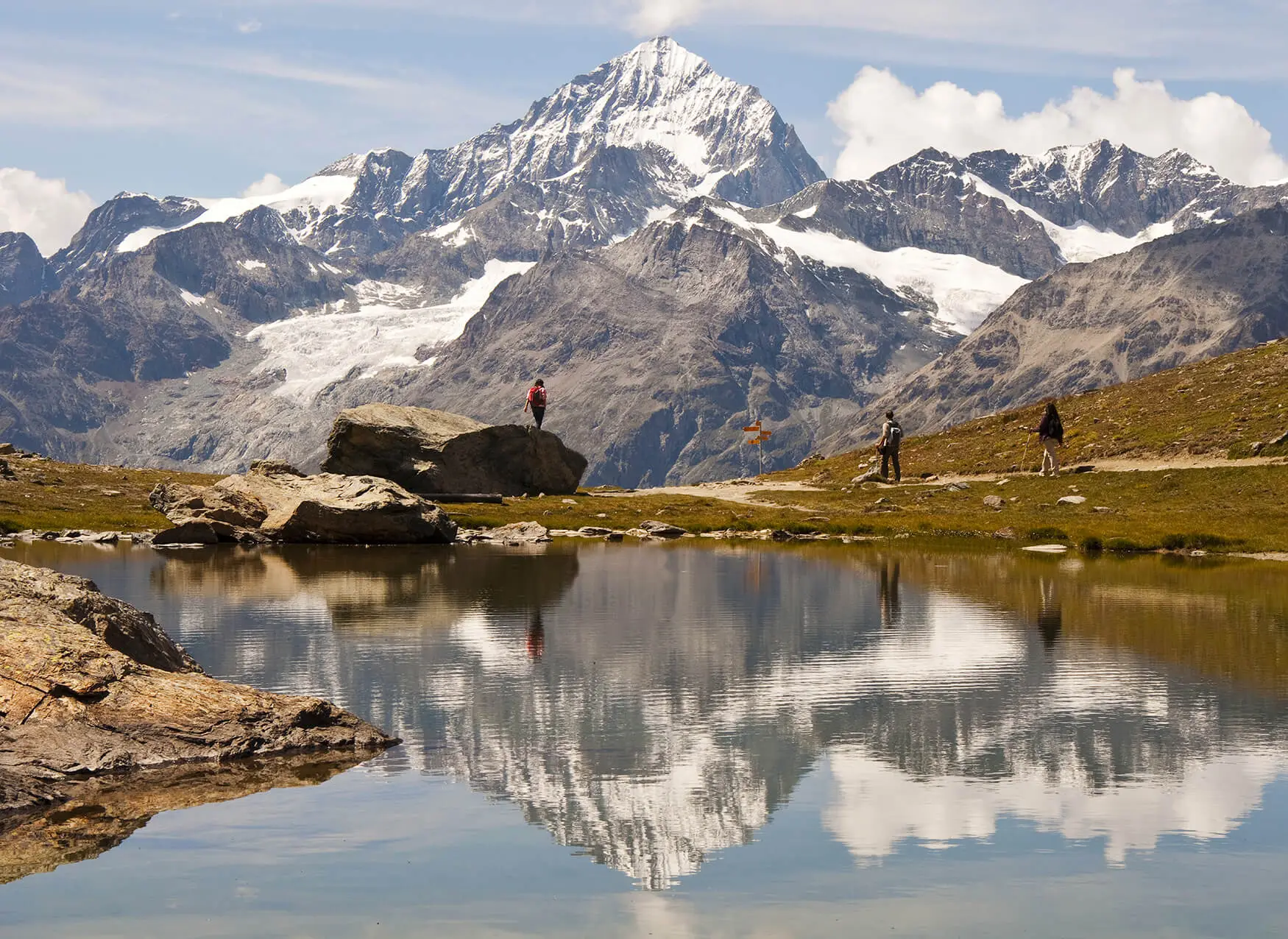 Hikers beside the Riffelsee mountain lake above Zermatt