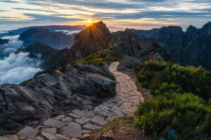 Stone hiking trail toward Pico Ruivo at sunrise above the clouds